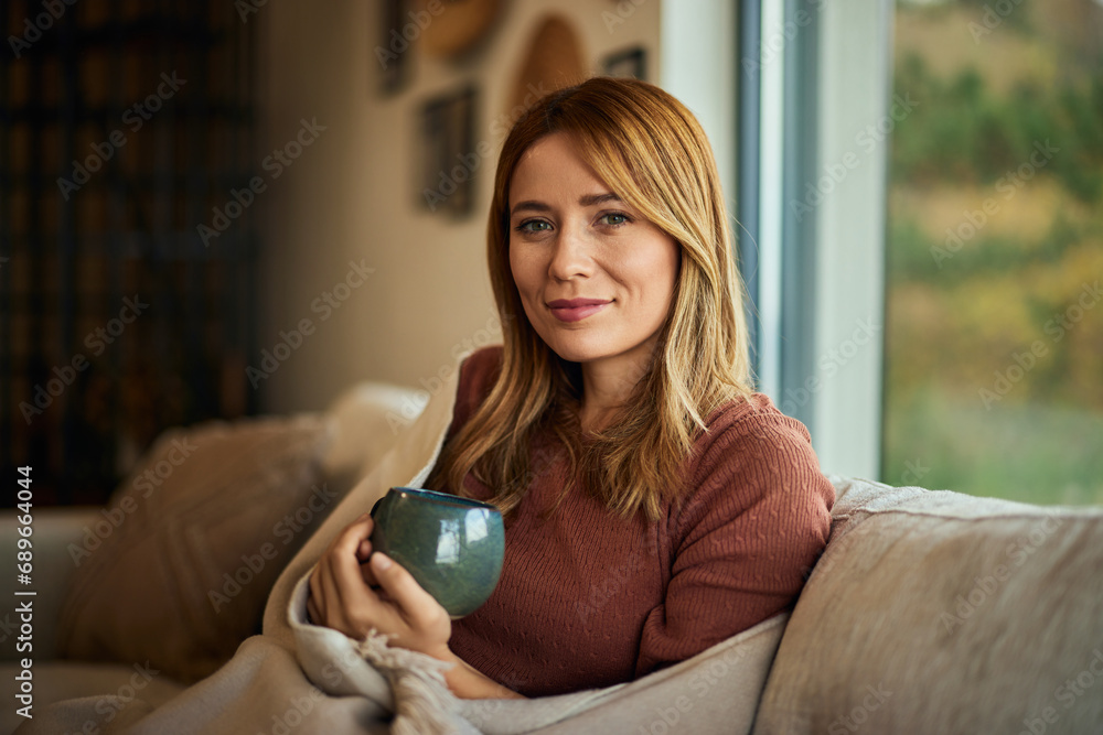 Portrait of a beautiful blonde female, holding a cup of coffee, enjoying the autumn season indoors. Portrait of a beautiful blonde female, holding a cup of coffee, enjoying the autumn season indoors.