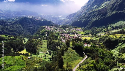Aerial drone view of Cirque de Salazie, with a creole village on a high plateau, red rooftops and high mountains, Reunion. photo