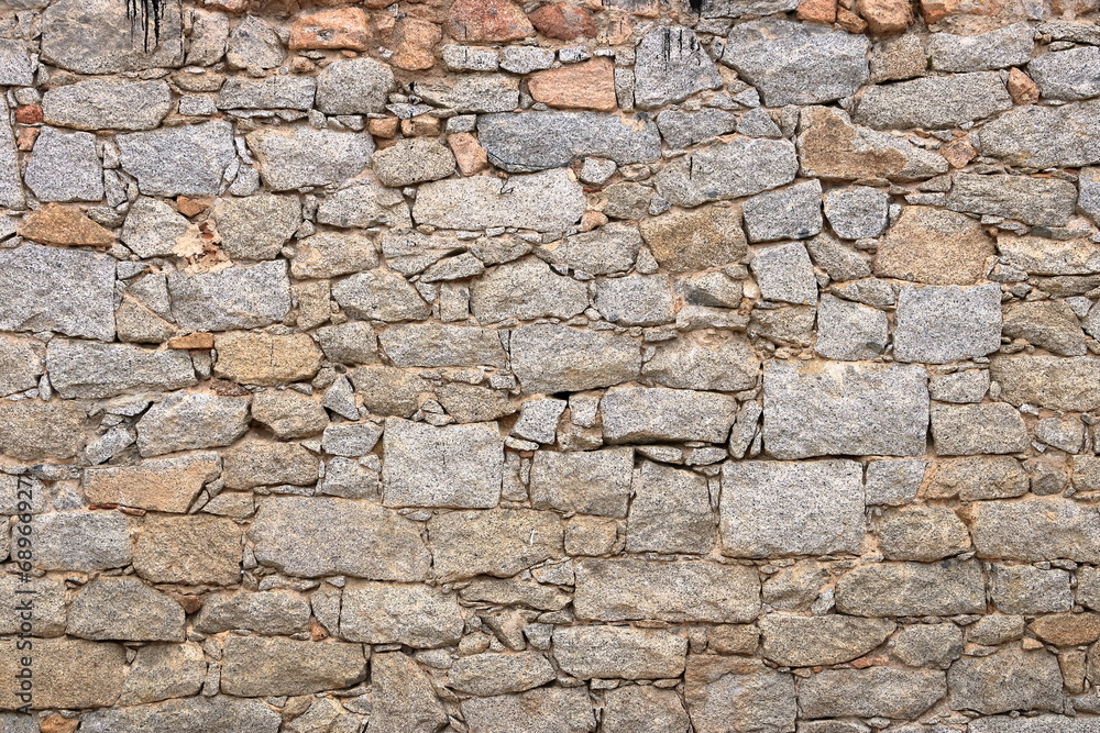 a yellow beige natural stone wall of different sized stones, traditional crafts a yellow beige natural stone wall of different sized stones, traditional crafts