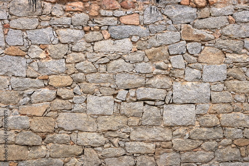 a yellow beige natural stone wall of different sized stones, traditional crafts