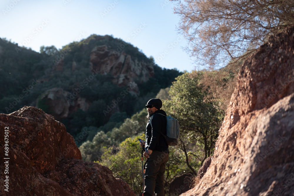 Obraz premium Middle-aged man contemplates the landscapes of the Garraf Natural Park while walking along the trails of a mountain.