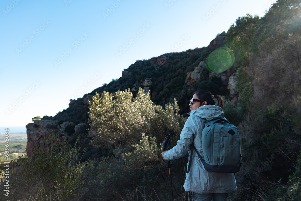 Woman contemplates the landscapes of the Garraf Natural Park while walking the paths of a mountain.