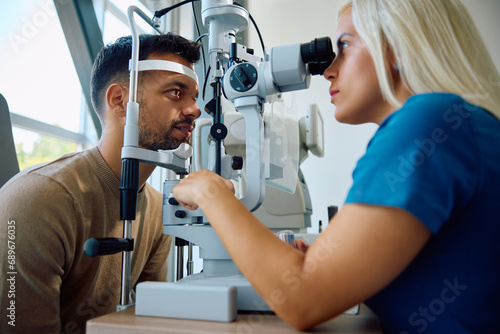 Young man having his eyes checked by ophthalmologist.
