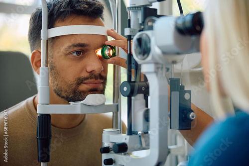 Young man during eye vision check at ophthalmology clinic.
