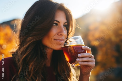 woman sipping amber ale outdoors photo