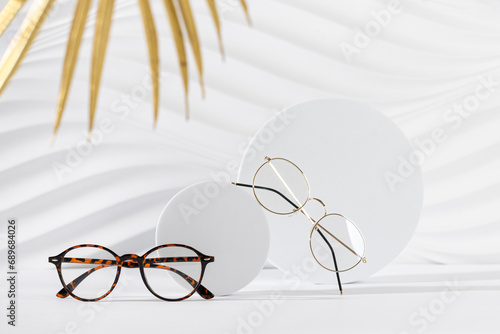 Two pairs of eyeglass frames on white background. Minimalism, eyewear fashion concept. Trendy eyeglasses still life in minimal style. Optic store discount, sale, promotion. Copy space for text