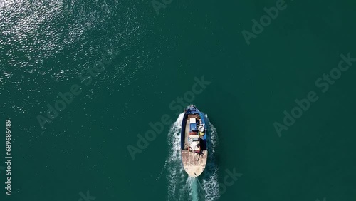 Aerial top view 4k footage by drone of fishing boat in the sea. photo