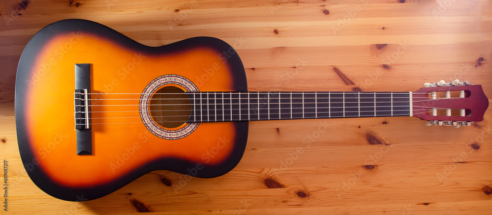 Fototapeta premium Musical instrument guitar on wooden background