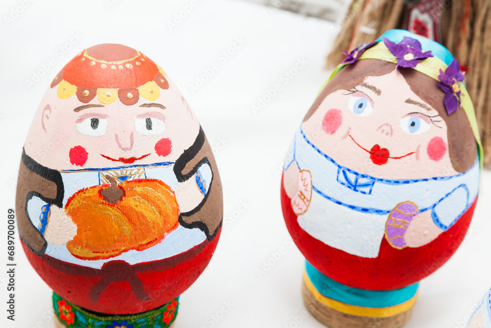Obraz premium two eggs painted with bright colors in the form of peoples faces.