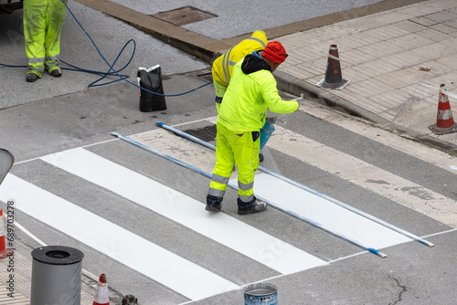Roadwork Workers painting a Pedestrian crosswalk on city