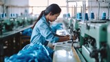 Young Asian woman tailor with experience sews things from natural fabric using sewing machine