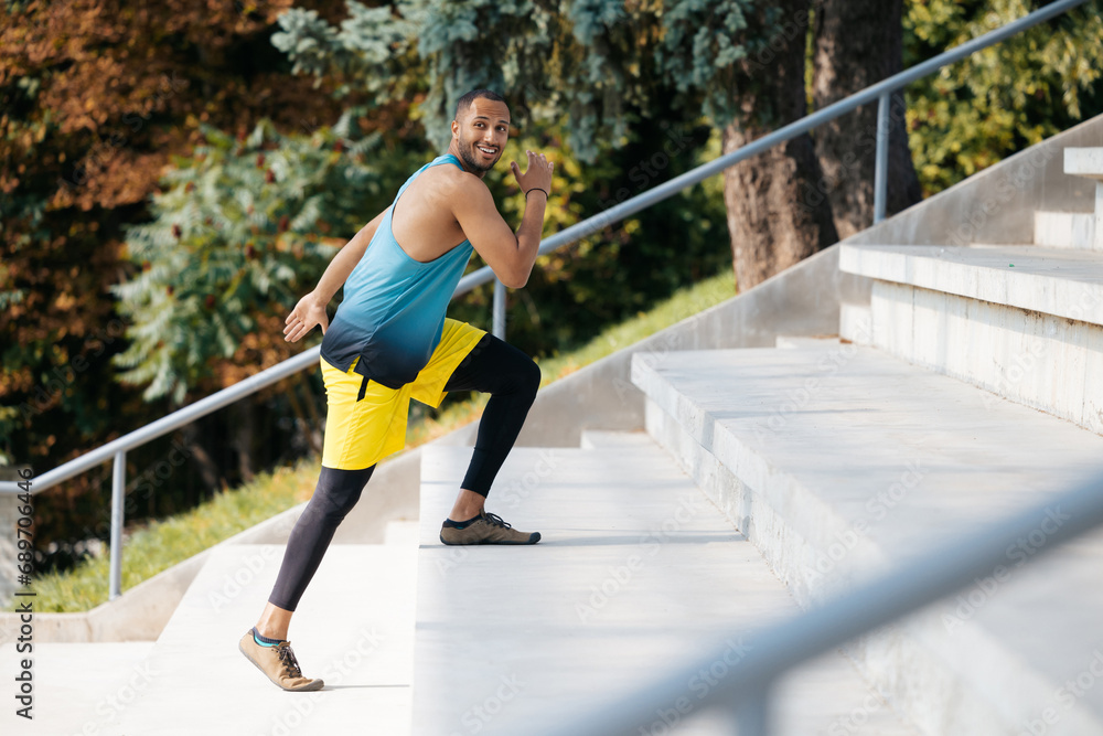 Dark-skinned sportsman running on the stairs during workout