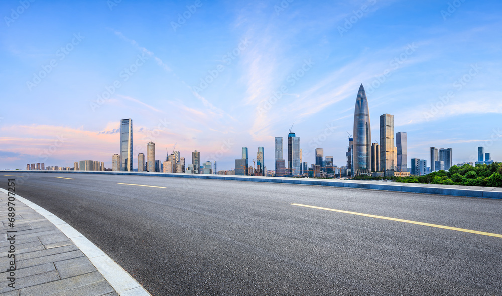 Asphalt road and urban skyline with modern buildings at sunrise in Shenzhen, Guangdong Province, China.