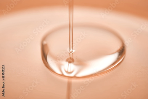 A juicy drop of gel on a Peach Fuzz background. photo