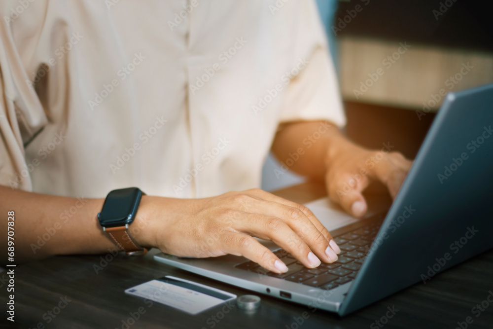 Close-up of male hands using laptop to work at home, finance concept, online shopping with credit card Close-up of male hands using laptop to work at home, finance concept, online shopping with credit card