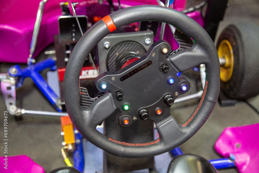 The steering wheel of racing car is black with control buttons. Cars, racing. The steering wheel of racing car is black with control buttons. Cars, racing.