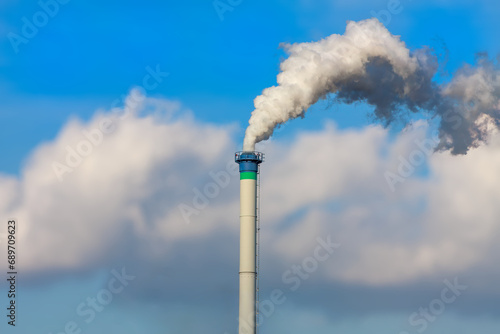 Smoking chimney against the blue sky
