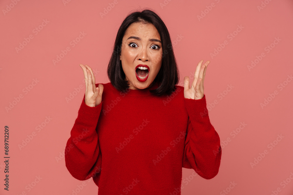 Furious woman screaming while standing isolated over pink background Furious woman screaming while standing isolated over pink background