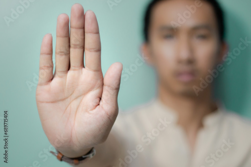 Man shows hand to stop or prohibit With a calm expression, the Asian man made a gesture, photo