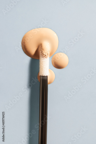 Cosmetic liquid concealer swatch drops with brush applicator photo