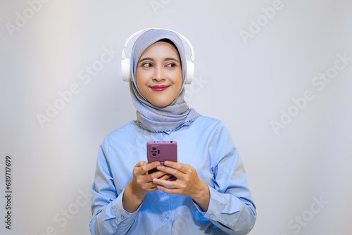 Cute young muslim woman enjoying music with headphone on. Enjoying music concept