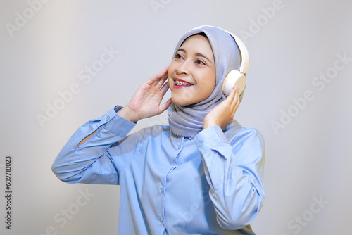 Cute young muslim woman enjoying music with headphone on. Enjoying music concept photo