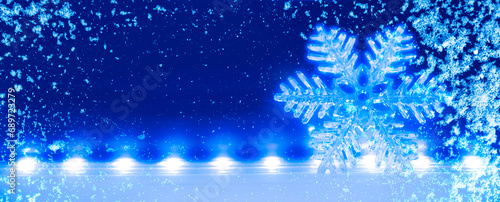 Blauer Leuchtender Weihanchtsstern vor unscharfem Hintergrund mit Schneeflocken