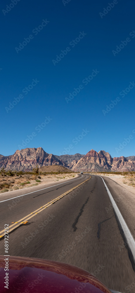 Empty long nevada mountain road to the horizon on a sunny summer day at bright sunset. vertical image for your reel and story
