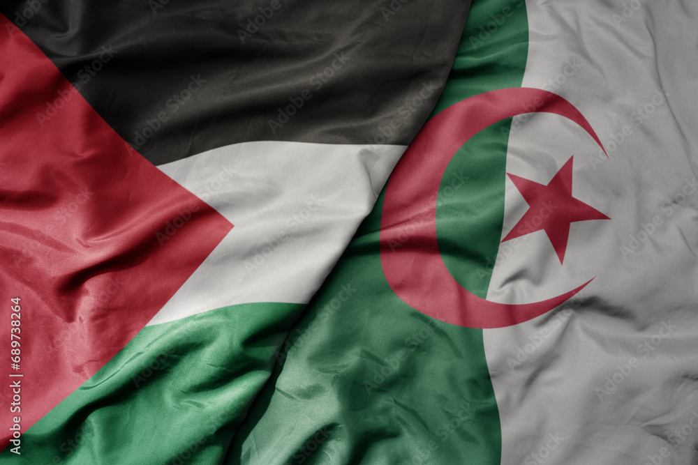 big waving national colorful flag of algeria and national flag of palestine .
