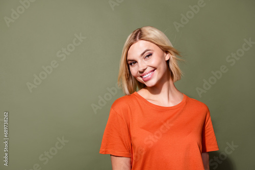 Photo portrait of pretty young girl fluttering hair volume toothy smile wear trendy orange outfit isolated on khaki color background