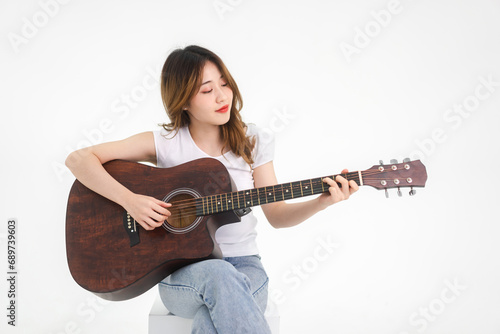 Asian teenager woman playing guitar song isolated white background