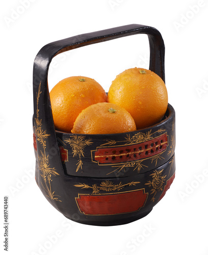 Mandarin oranges are in a tiffin or basket called Bakul Siah, traditional Peranakan Baba Malay art. photo
