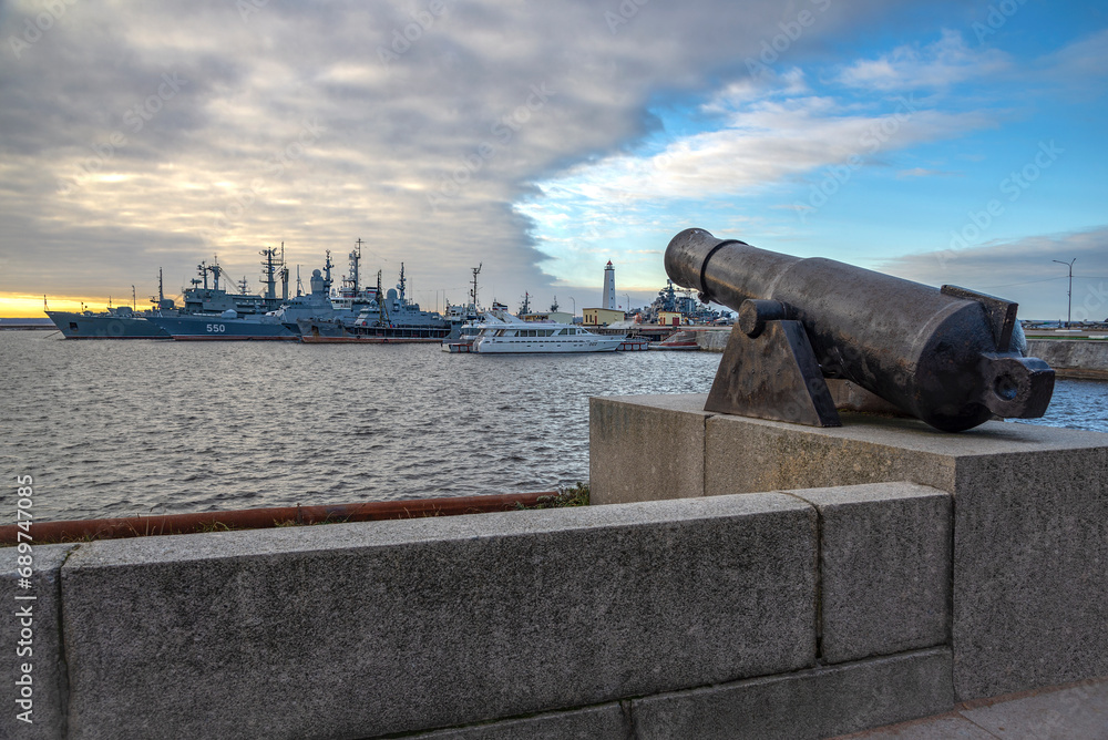 A noon cannon on the background of the ships of the Baltic Fleet. Kronstadt, Russia