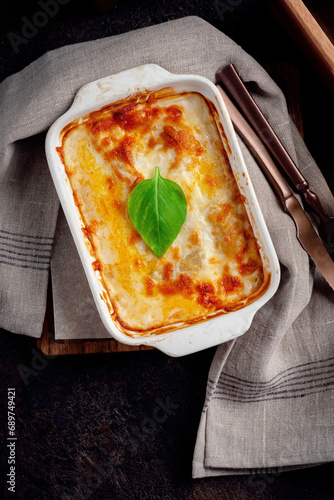 Lasagna with meat baked in the oven with tomato sauce and cheese in ceramic dishes and served on the table. Homemade lasagna bolognese in rustic style, top view