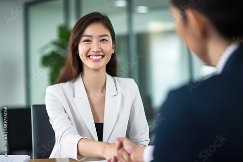 Fototapeta Naklejka Na Ścianę i Meble -  Happy business woman manager handshaking at office meeting. Smiling female hr hiring recruit at job interview, bank or insurance agent, lawyer making contract deal with client at work.