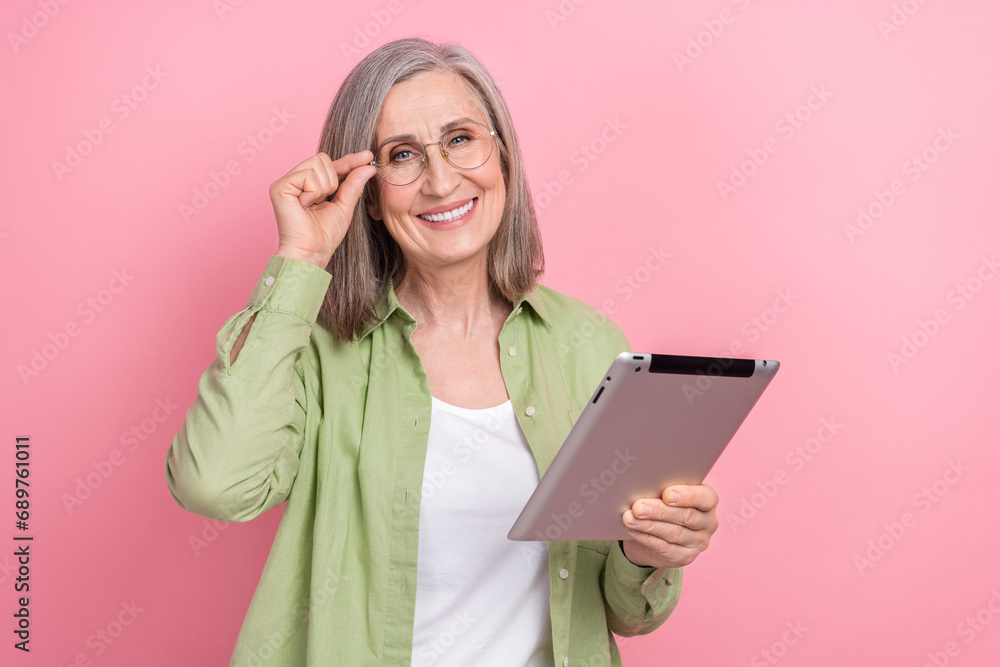 Photo clever retired woman touch spectacles browsing concentrated modern tablet good productivity device isolated on pink color background Photo clever retired woman touch spectacles browsing concentrated modern tablet good productivity device isolated on pink color background