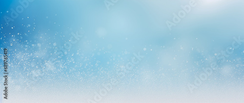 A gradient blue and white watercolor background with white splatters  resembles snow scattered throughout the image. Winter background.