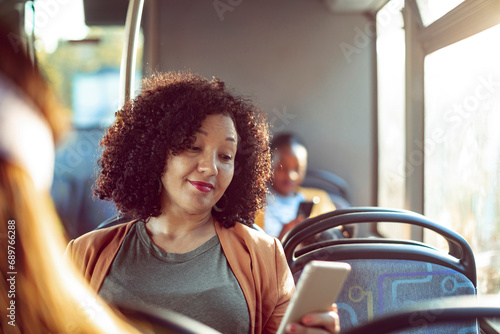Smiling woman using smartphone on the bus photo