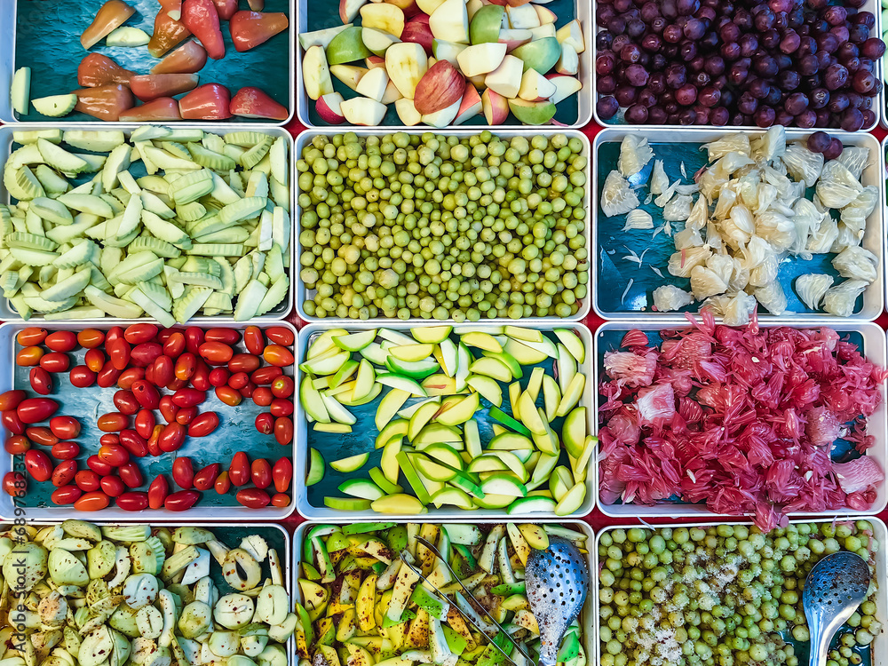 Top view of assorted fruits and pickled fruits on trays for sale in street market, healthy food concept Include high vitamin fruits, fresh fruits, Thai fruits, Street food.Variety fruits as background Top view of assorted fruits and pickled fruits on trays for sale in street market, healthy food concept Include high vitamin fruits, fresh fruits, Thai fruits, Street food.Variety fruits as background