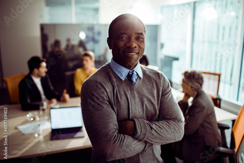 Middle aged black businessman smiling and looking at camera in office photo