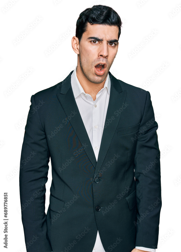 Handsome hispanic man wearing business clothes in shock face, looking skeptical and sarcastic, surprised with open mouth Handsome hispanic man wearing business clothes in shock face, looking skeptical and sarcastic, surprised with open mouth