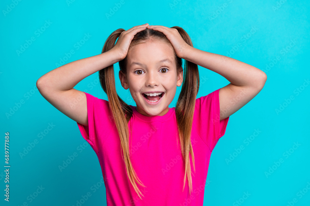 Portrait of impressed cheerful schoolkid arms touch head unbelievable reaction isolated on turquoise color background