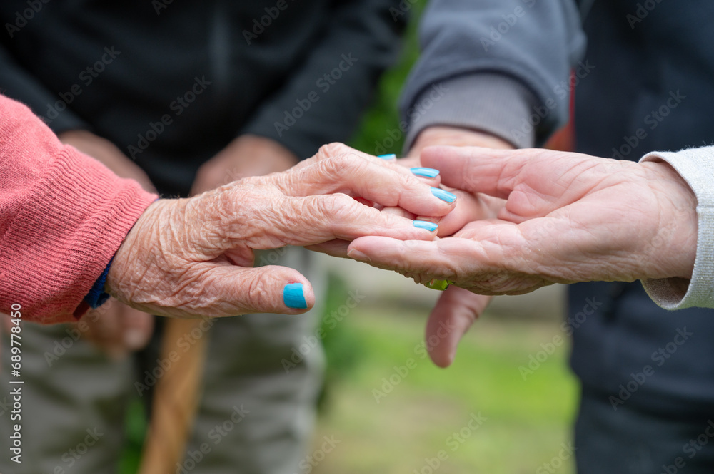 Closeup of elderly couple holding hands. Husband and wife holding hands and comforting each other. Love and care concept. High quality photo