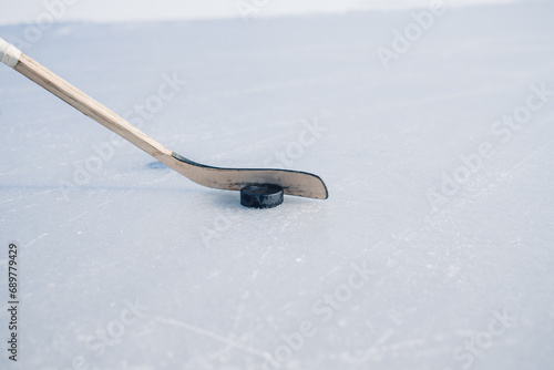 Close-up, hockey stick and puck on ice.