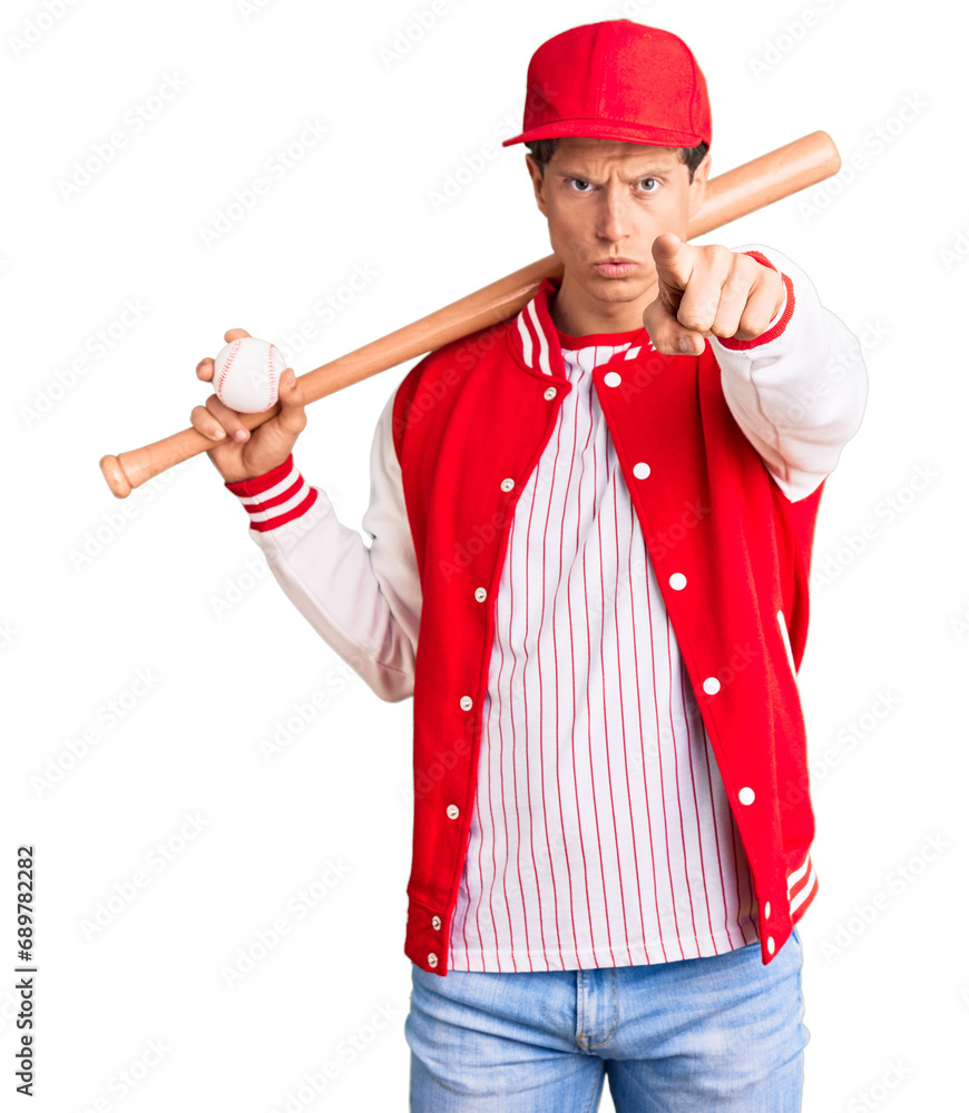 Young handsome man playing baseball holding bat and ball pointing with finger to the camera and to you, confident gesture looking serious Young handsome man playing baseball holding bat and ball pointing with finger to the camera and to you, confident gesture looking serious