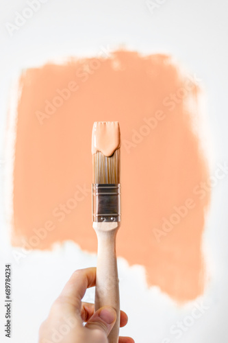 Foto Process of choosing paint for the walls during house renovation, peach fuzz colo