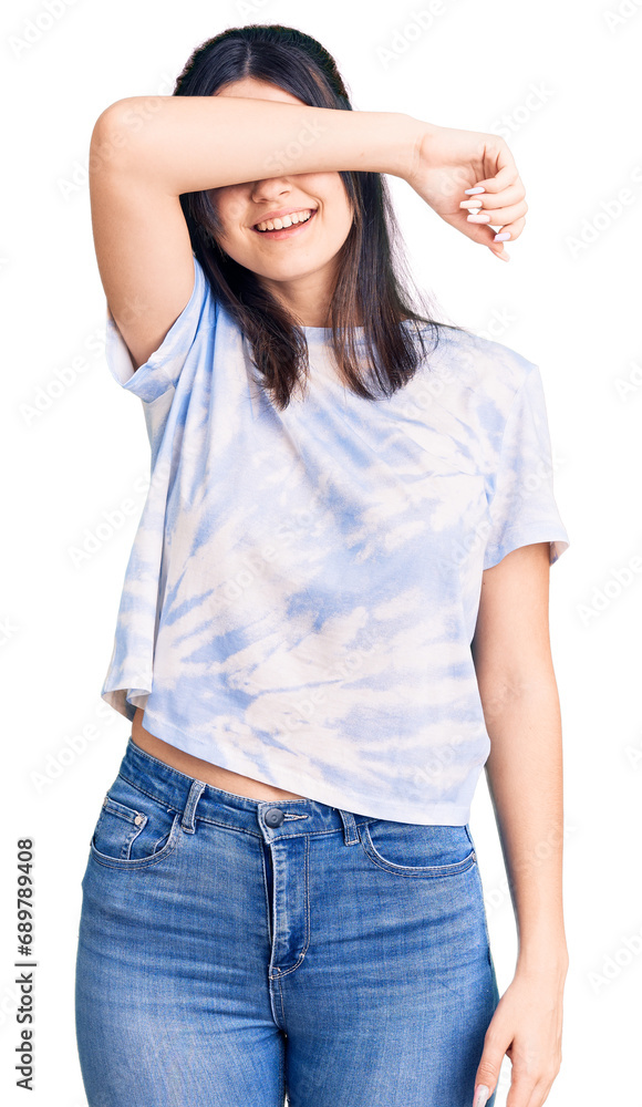 Young beautiful girl wearing casual t shirt covering eyes with arm smiling cheerful and funny. blind concept. Young beautiful girl wearing casual t shirt covering eyes with arm smiling cheerful and funny. blind concept.