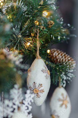 Christmas background with pine branch and beautiful colored shiny bokeh. Wool pine cones. New Years. Shallow depth of field.