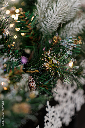 Christmas blurred background, pine branch with snow and beautiful white shiny bokeh. New Years. Airy atmosphere.