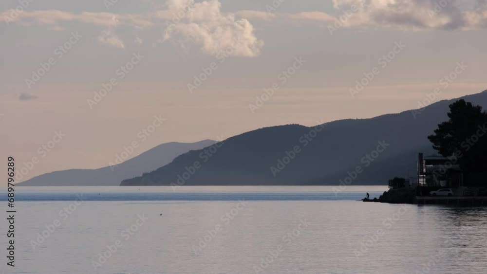 Silhouette of couple standing on a SUP board and exercising at sunset. Active people stand up paddling and enjoy tropical evening sunshine in Mediterranean Sea. Sporty vacation or holiday concept. Silhouette of couple standing on a SUP board and exercising at sunset. Active people stand up paddling and enjoy tropical evening sunshine in Mediterranean Sea. Sporty vacation or holiday concept.